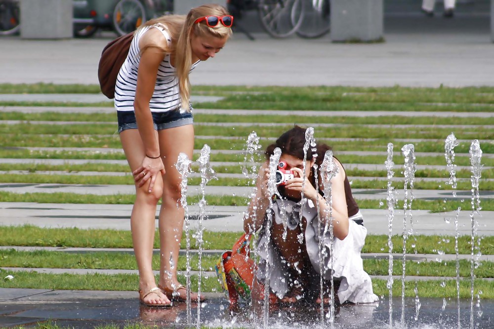 two sexy and young girls takes photos on a fountain pict gal